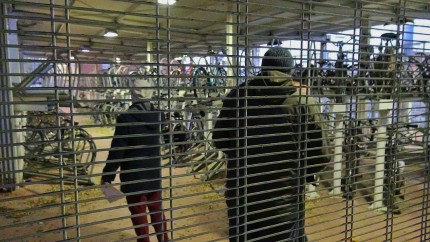 What more could a suburban bicyclist commuter want than secure storage facilities at the railstation? Image shows about 50 bikes stacked neatly. 